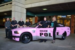 Salem Police Foundation Members pose with the Salem Police Department pink patrol car
